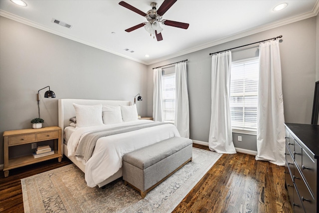 bedroom featuring dark wood-type flooring, visible vents, crown molding, and baseboards