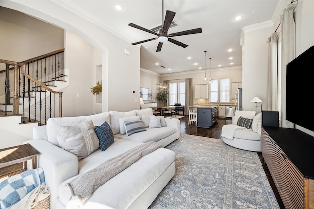 living area with arched walkways, recessed lighting, ornamental molding, stairway, and dark wood-style floors