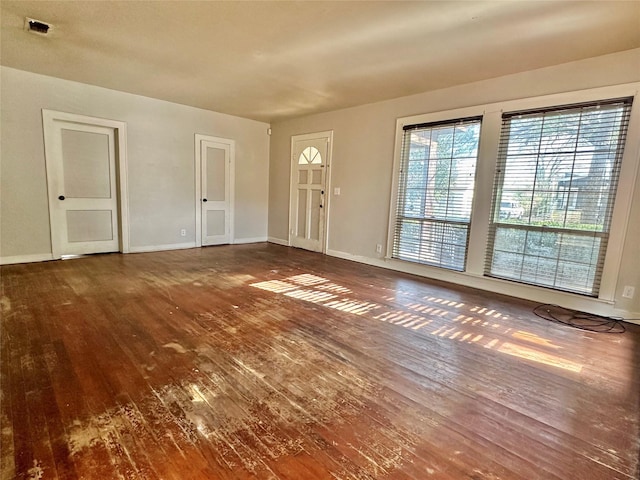 interior space featuring hardwood / wood-style floors, visible vents, and baseboards