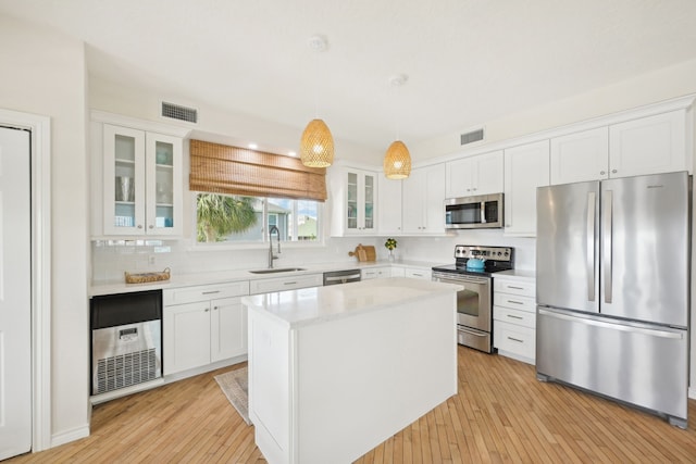 4105 Nueces Dr, Galveston, TX 77554 - kitchen featuring pendant lighting, stainless steel appliances, light countertops, glass insert cabinets, and a sink