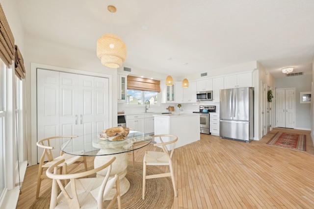 4105 Nueces Dr, Galveston, TX 77554 - dining room with light wood-style floors and visible vents