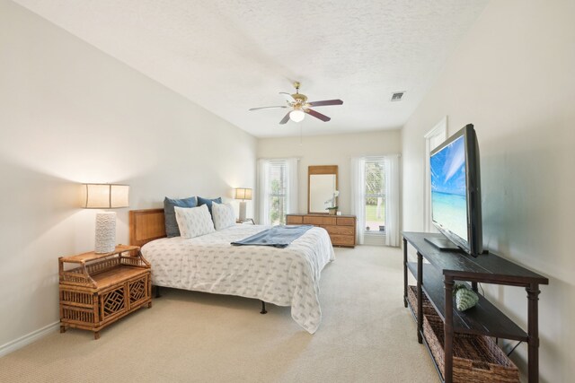 4105 Nueces Dr, Galveston, TX 77554 - bedroom featuring light colored carpet, visible vents, a ceiling fan, a textured ceiling, and baseboards