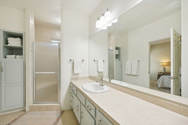 4105 Nueces Dr, Galveston, TX 77554 - ensuite bathroom featuring a textured ceiling, vanity, a shower stall, tile patterned floors, and ensuite bath