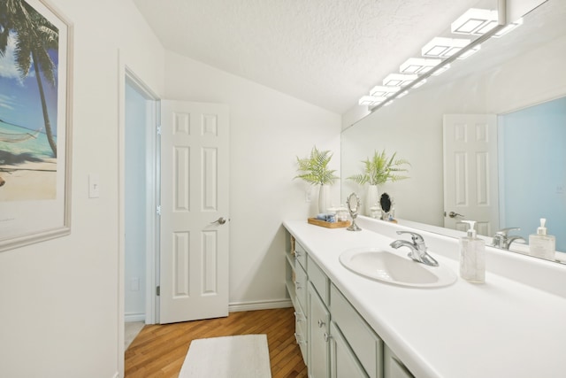 4105 Nueces Dr, Galveston, TX 77554 - bathroom with baseboards, lofted ceiling, wood finished floors, a textured ceiling, and vanity