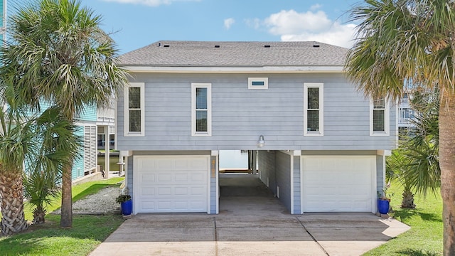 4105 Nueces Dr, Galveston, TX 77554 - exterior space featuring an attached garage, a shingled roof, and concrete driveway