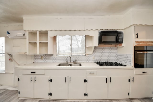 kitchen with open shelves, black appliances, light countertops, and a sink