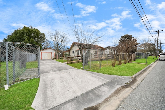 view of front of property featuring an outbuilding, a detached garage, a front yard, fence, and a residential view