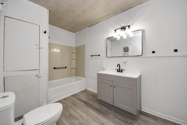 bathroom with a textured ceiling, vanity, wood finished floors, and toilet