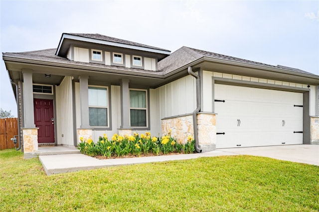 prairie-style house with a garage, fence, concrete driveway, board and batten siding, and a front yard