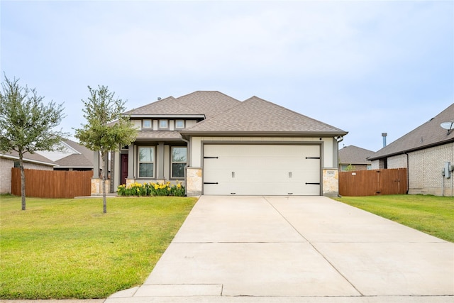 view of front facade featuring a shingled roof, an attached garage, fence, driveway, and a front lawn