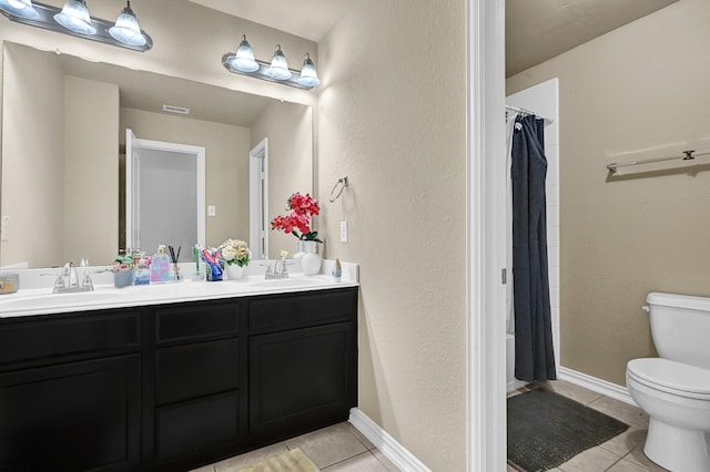 bathroom with double vanity, a sink, and tile patterned floors