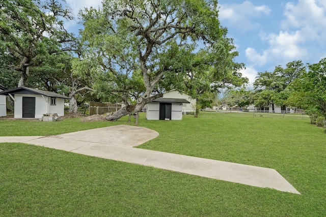 view of yard with a storage shed, fence, and an outbuilding