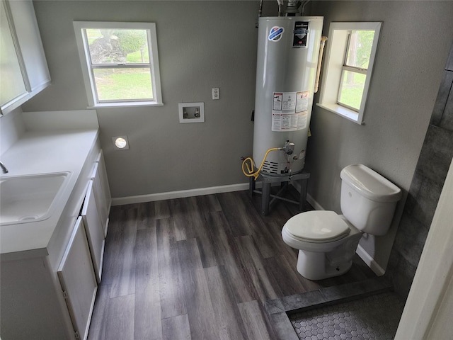 bathroom featuring toilet, baseboards, gas water heater, and wood finished floors