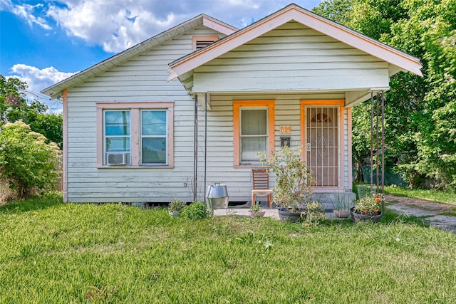 bungalow-style home featuring covered porch and a front yard