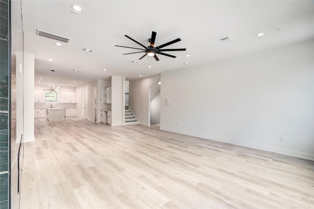 unfurnished living room with light wood-type flooring, stairs, visible vents, and recessed lighting