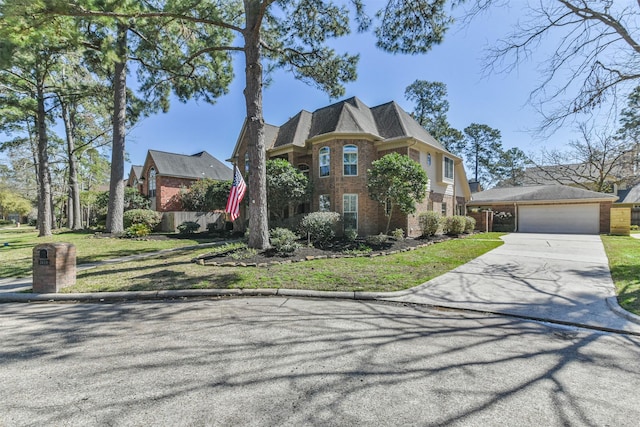 view of front of home featuring a front yard, concrete driveway, brick siding, and an attached garage