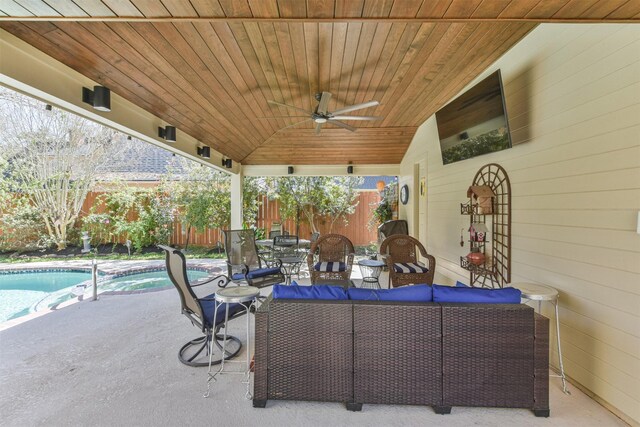 view of patio featuring ceiling fan, a fenced backyard, a pool with connected hot tub, and an outdoor living space