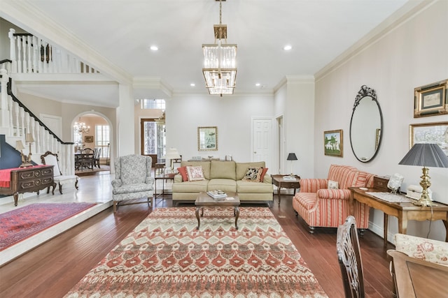 living room featuring arched walkways, dark wood-style flooring, crown molding, a chandelier, and recessed lighting