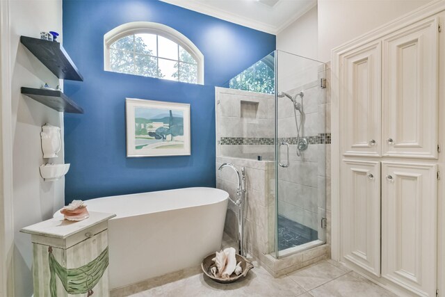 full bath with ornamental molding, a freestanding tub, a shower stall, and tile patterned flooring