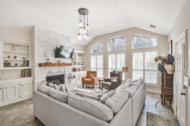 living room featuring lofted ceiling, visible vents, a fireplace, and built in features