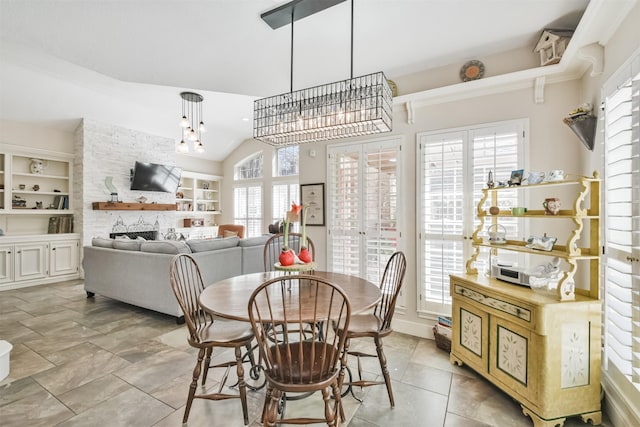 dining room with a chandelier, lofted ceiling, a wealth of natural light, and built in features