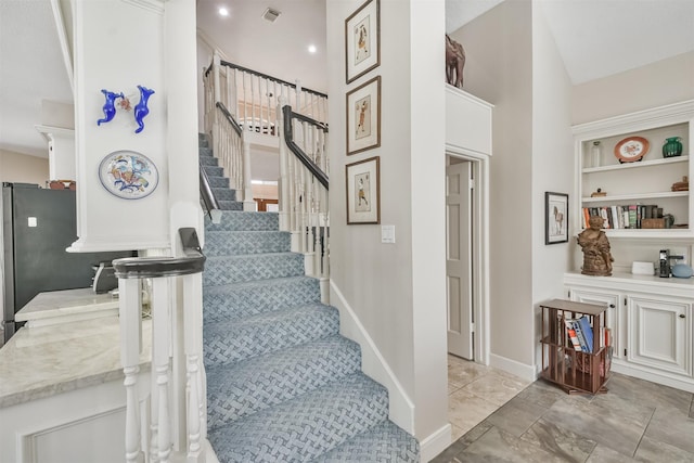 stairs with built in features, visible vents, and baseboards