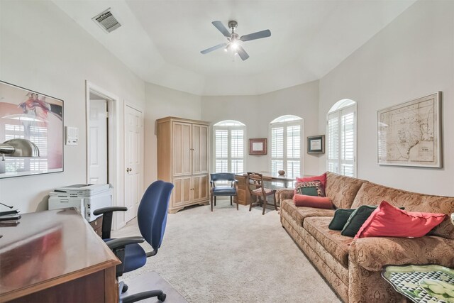 office area with light carpet, a tray ceiling, visible vents, and a ceiling fan