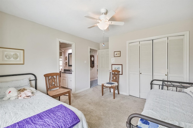 bedroom with a closet, a ceiling fan, light carpet, ensuite bath, and baseboards