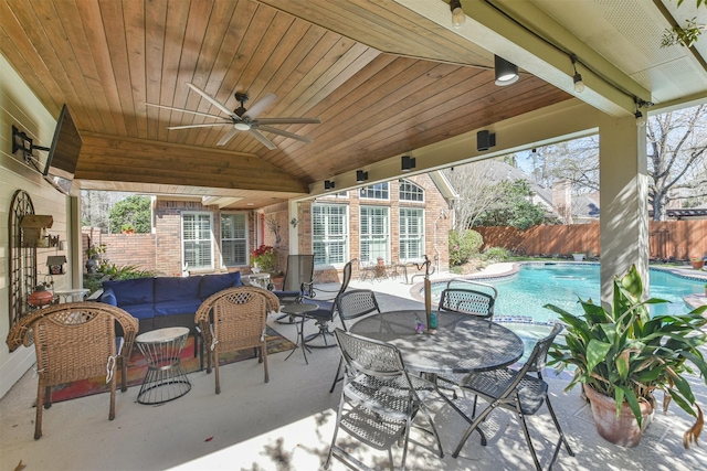 view of patio / terrace with an outdoor hangout area, ceiling fan, fence, and a fenced in pool