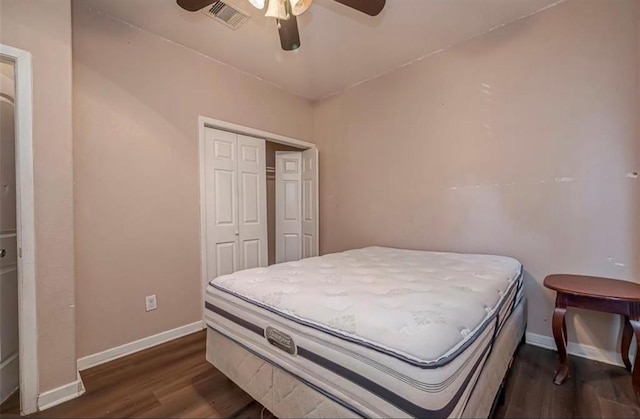 bedroom with dark wood-type flooring, a closet, visible vents, and baseboards