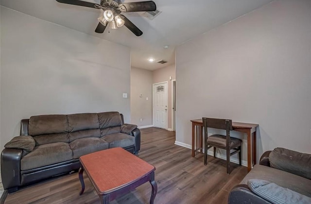 living room featuring visible vents, dark wood finished floors, and baseboards