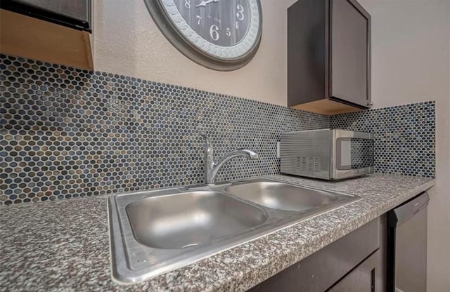 interior details with tasteful backsplash, appliances with stainless steel finishes, and a sink