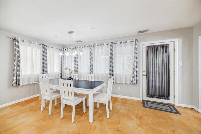 dining room featuring visible vents, baseboards, and wood finished floors