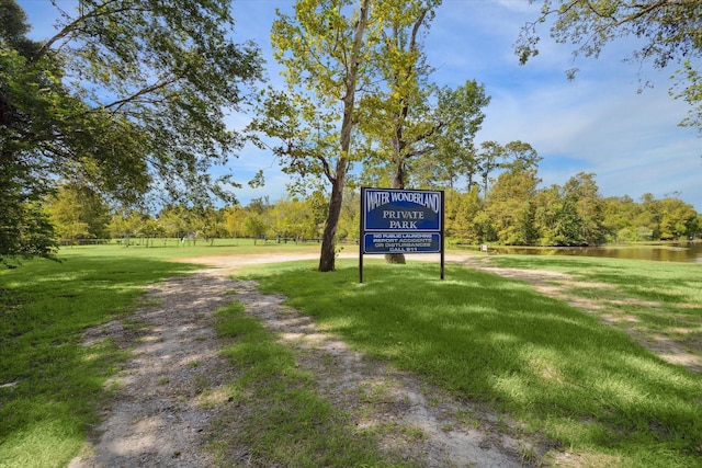 surrounding community featuring a water view and a lawn