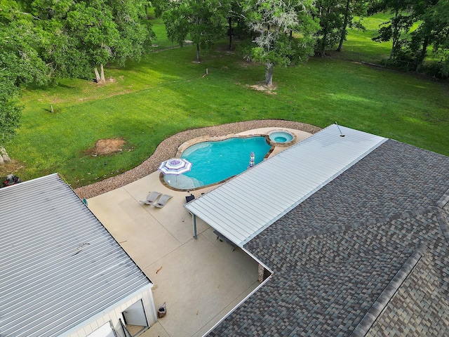 view of pool with a pool with connected hot tub, a patio area, and a lawn