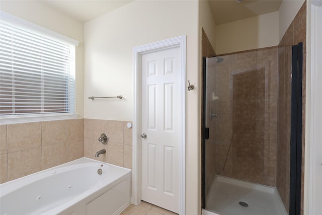 bathroom with a whirlpool tub, a stall shower, and tile patterned flooring