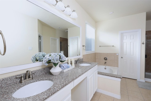 full bath with double vanity, a garden tub, tile patterned flooring, and a sink