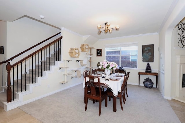 dining area with a chandelier, baseboards, stairs, ornamental molding, and a glass covered fireplace