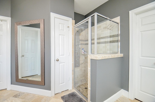 full bathroom featuring a stall shower and baseboards