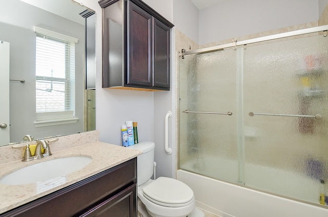 full bath with combined bath / shower with glass door, vanity, and toilet