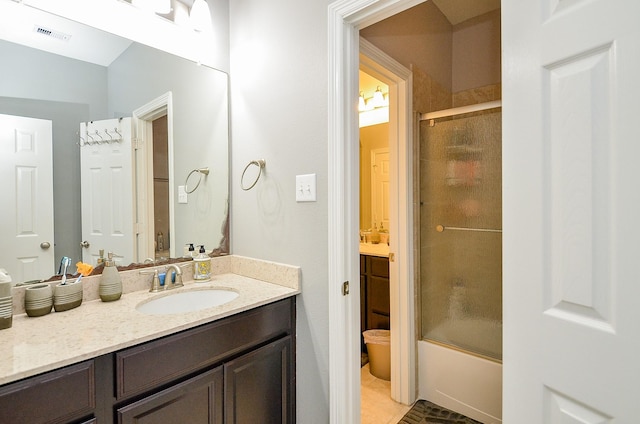 bathroom featuring visible vents, vanity, and combined bath / shower with glass door