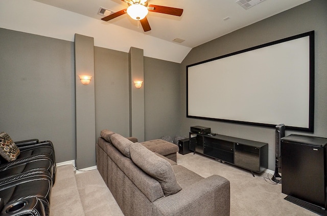 cinema room with visible vents, vaulted ceiling, a ceiling fan, and light colored carpet