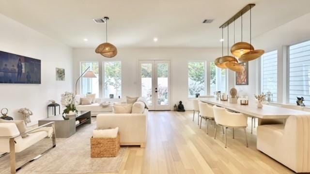 living area with light wood-type flooring, recessed lighting, visible vents, and french doors