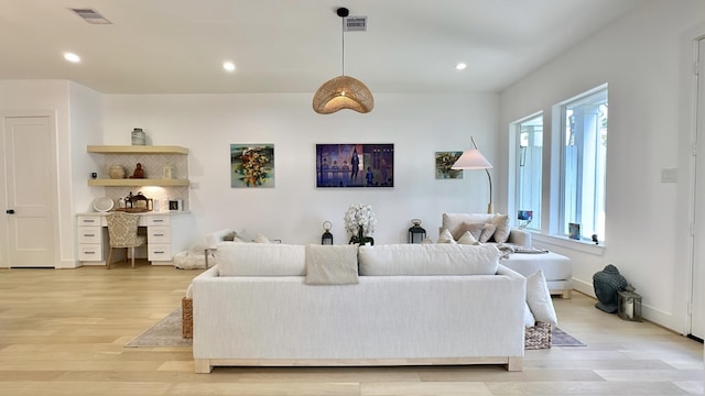 living room with light wood-style flooring, visible vents, and recessed lighting