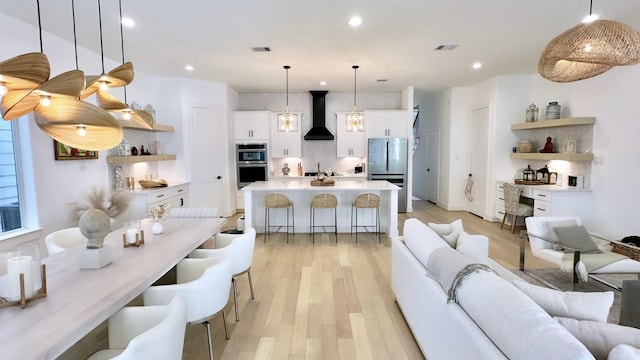 living room with recessed lighting, visible vents, and light wood-style floors