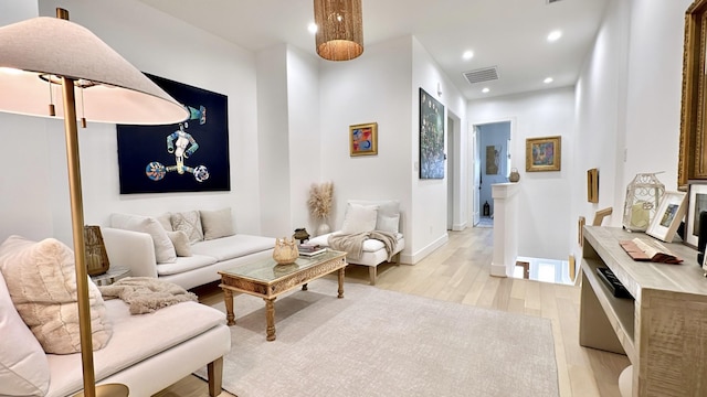 living room featuring light wood-type flooring, baseboards, visible vents, and recessed lighting