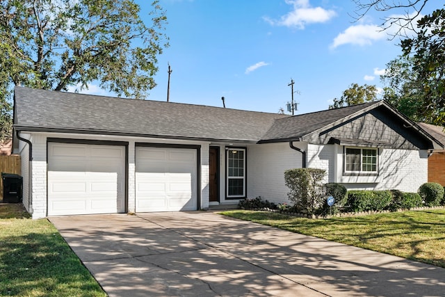 ranch-style home with a front yard, concrete driveway, brick siding, and an attached garage