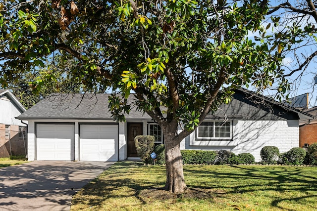 view of front facade featuring brick siding, roof with shingles, a front yard, a garage, and driveway