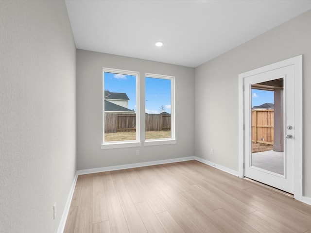 spare room featuring light wood-style floors and baseboards