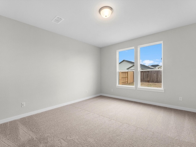 carpeted empty room with visible vents and baseboards